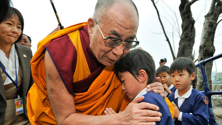 Его Святейшество Далай-лама утешает выжившую девочку во время посещения пострадавшего от цунами региона Сендай, Япония, 5 ноября 2011 г. (Фото: Тензин Чойджор, офис ЕСДЛ)